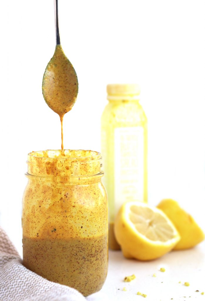 almond turmeric dressing with a spoon dripping with sauce.