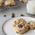 oatmeal cookies on a plate with milk next to it.