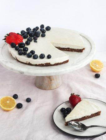 vegan cheesecake on a plate with fruit on top.