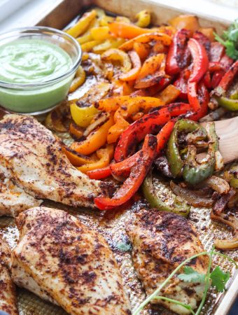 These one sheet pan chicken fajitas with avocado sauce can be made in under 30 minutes and is an easy clean up! Peppers, avocado and low sodium fajita seasoning makes for a heart healthy meal. | mealswithmaggie.com #hearthealthy #onesheetpandinner #onesheetpanchickenfajitas #avocadosauce #lowsodiumfajitas #quickandeasydinner #mealprep