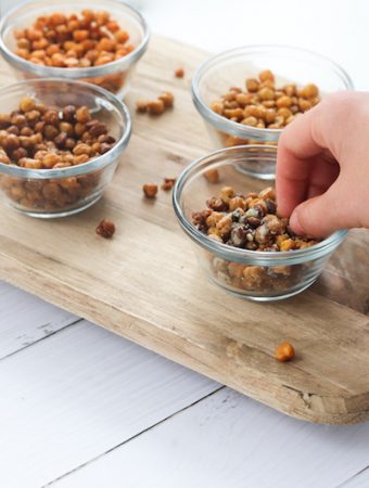 Roasted chickpeas seasoned 4 ways is a great snack under 100 calories a serving and provides about 4 grams of fiber and protein in a serving! They are easy to prepare and can be used in soups, salads, pasta or rice dishes or eaten straight from the oven. | mealswithmaggie.com #5ingredientsorless #roastedchickpeas #crunchy #easymealprep #easysnackidea #lowcaloriesnack #highproteinsnack #highfibersnack