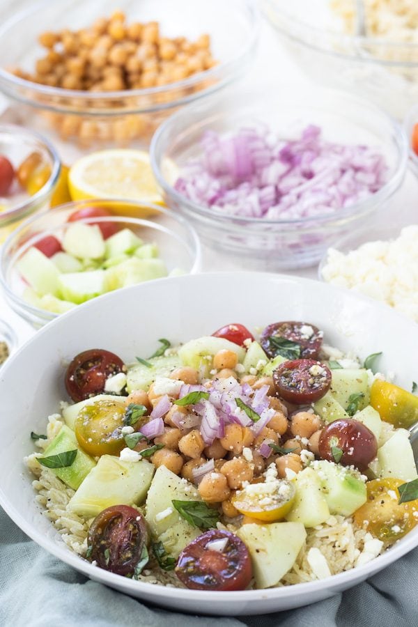 This Greek Orzo Salad is full of fresh, bright ingredients with Middle Eastern spices. A great vegetarian option for meal prep or potluck. | Mealswithmaggie.com #greekorzosalad #mealpreplunch #vegetarian #easygreeksalad #easypastasalad #pastasalad #greekpastasalad