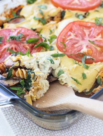 a casserole dish filled with pasta and tomatoes with sauce.