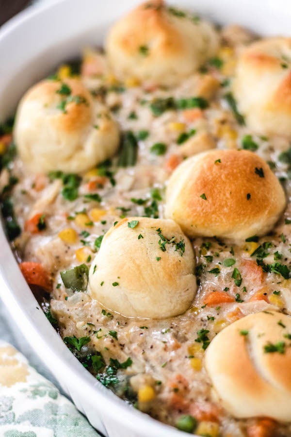 chicken pot pie with biscuits in a casserole dish.