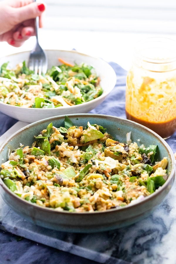 Salad in a bowl with dressing on top.