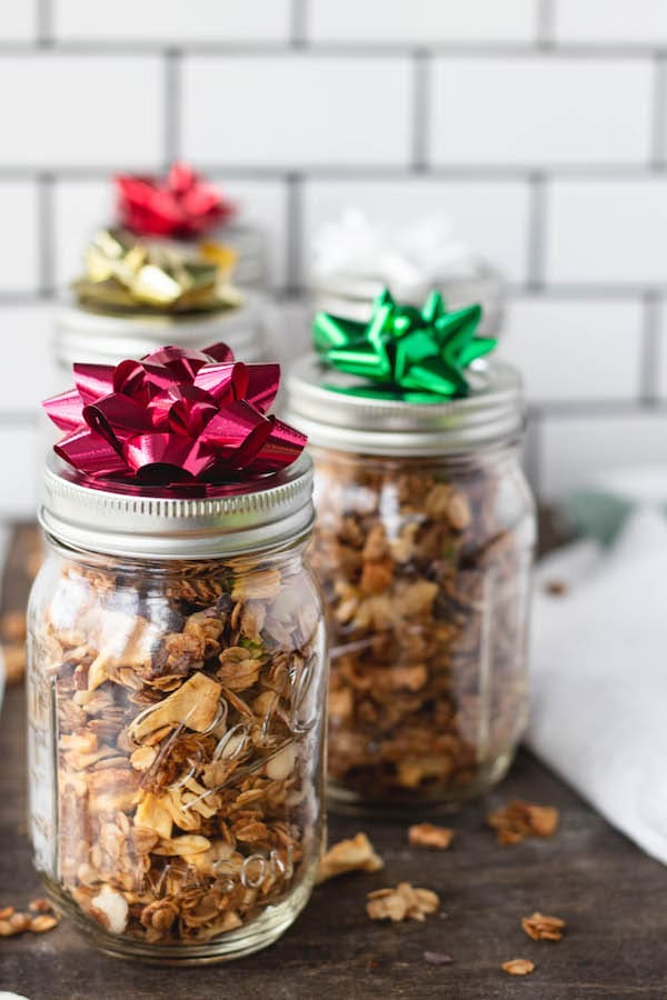 Mason jars filled with granola and a bow on top.