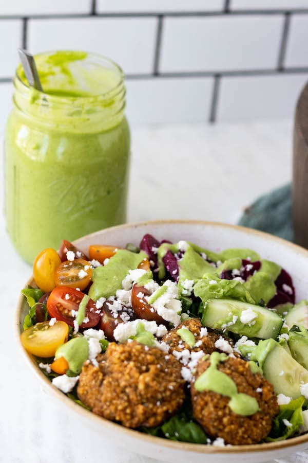 salad with green goddess dressing on top in a bowl with a fork