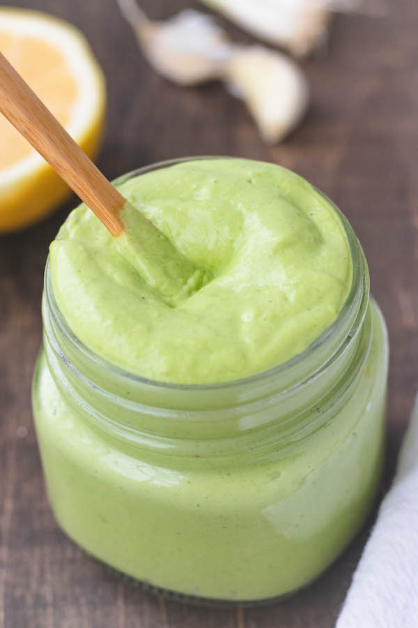 avocado green goddess dressing in a jar with a spoon