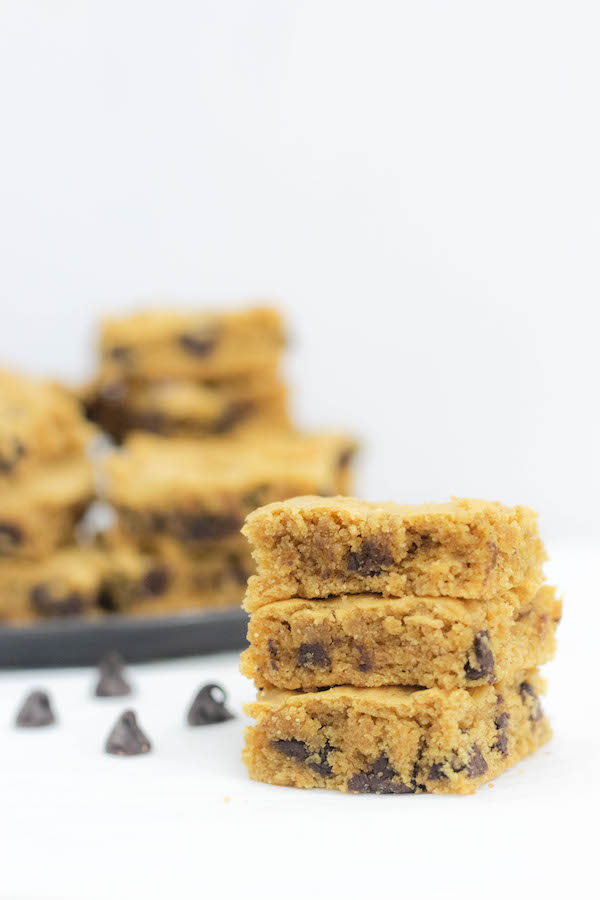 Healthy Peanut Butter Brownies stacked on a plate with chocolate chips