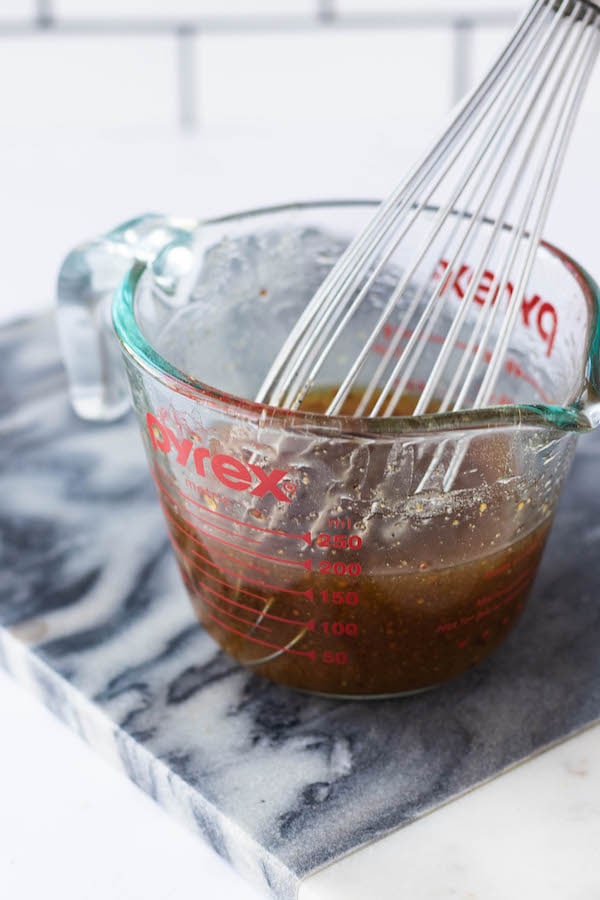 mixing cup of maple glaze with whisk