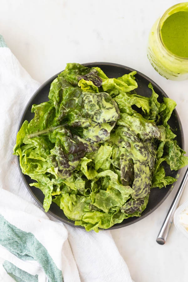 Green lettuce on a plate with dressing. 