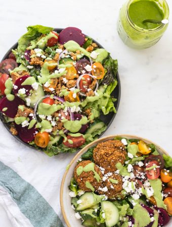 two salads in bowls with green goddess dressing drizzle