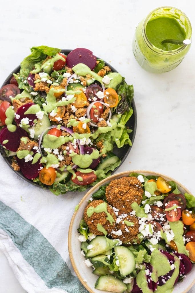 salads on a plate with toppings and dressing.