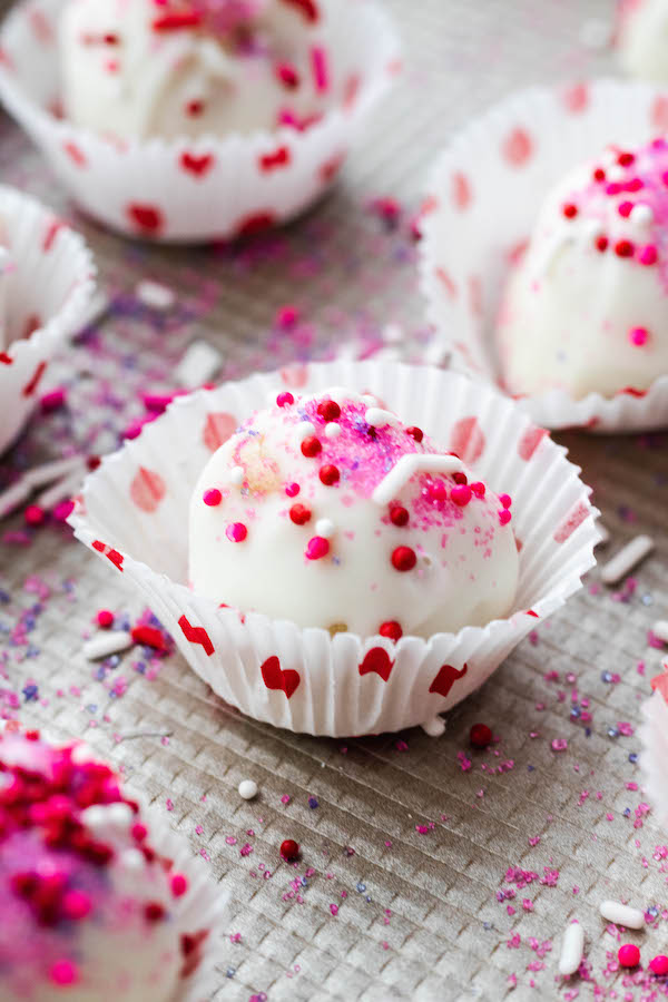 Sugar cookie Bite in a wrapper with sprinkles around it.