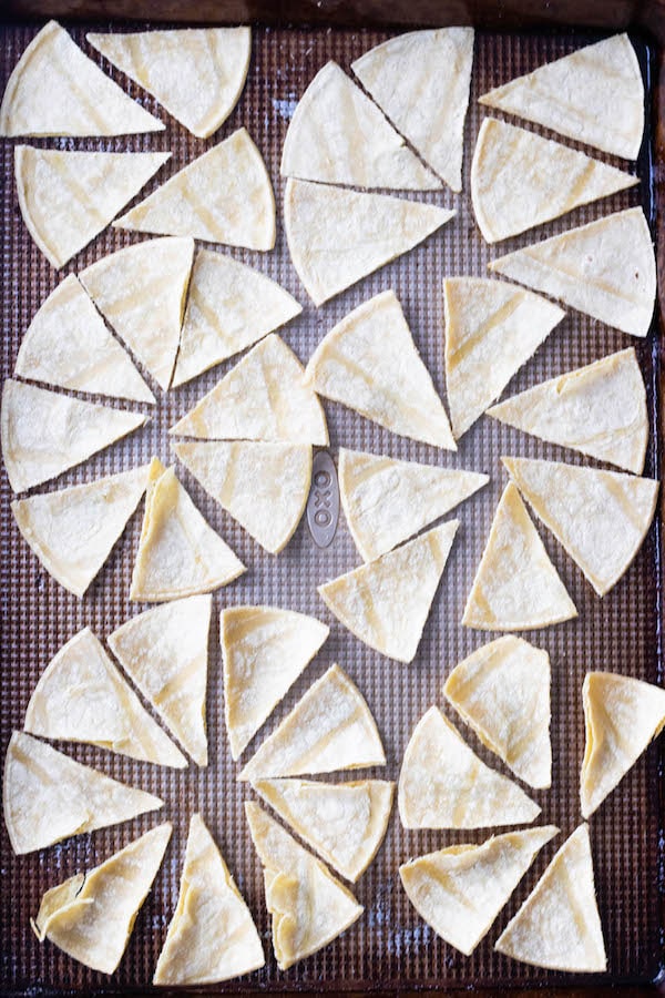 corn tortillas lined on a sheet pan