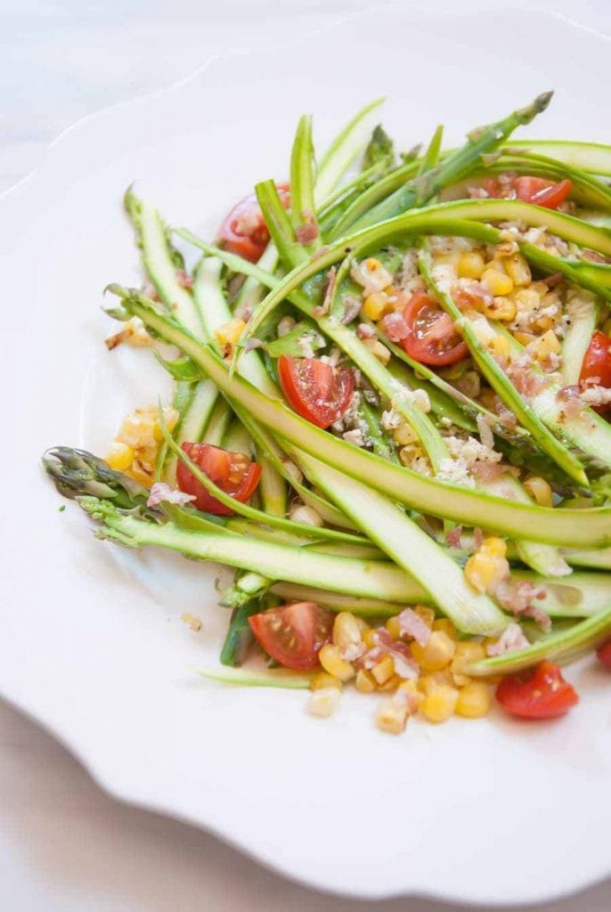 shaved asparagus with tomatoes and corn in it.