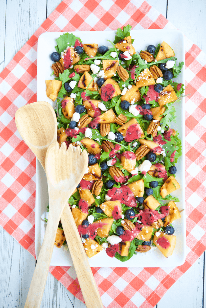 A fresh summer salad recipe that has chunks of fruits, nuts and vegetables in it.