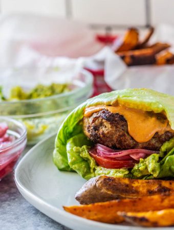 Turkey burger on a plate with fries next to it.