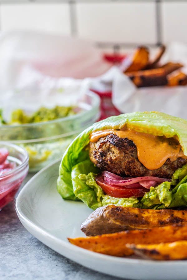 Envuelta de hamburguesa de pavo en un plato con patatas fritas al lado.