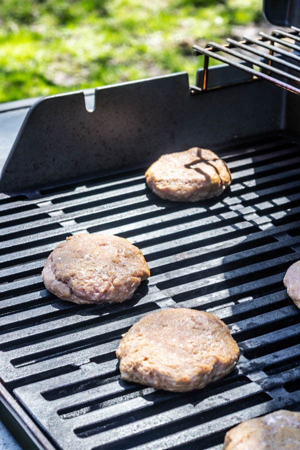 Grilled turkey burgers on a grill outside.