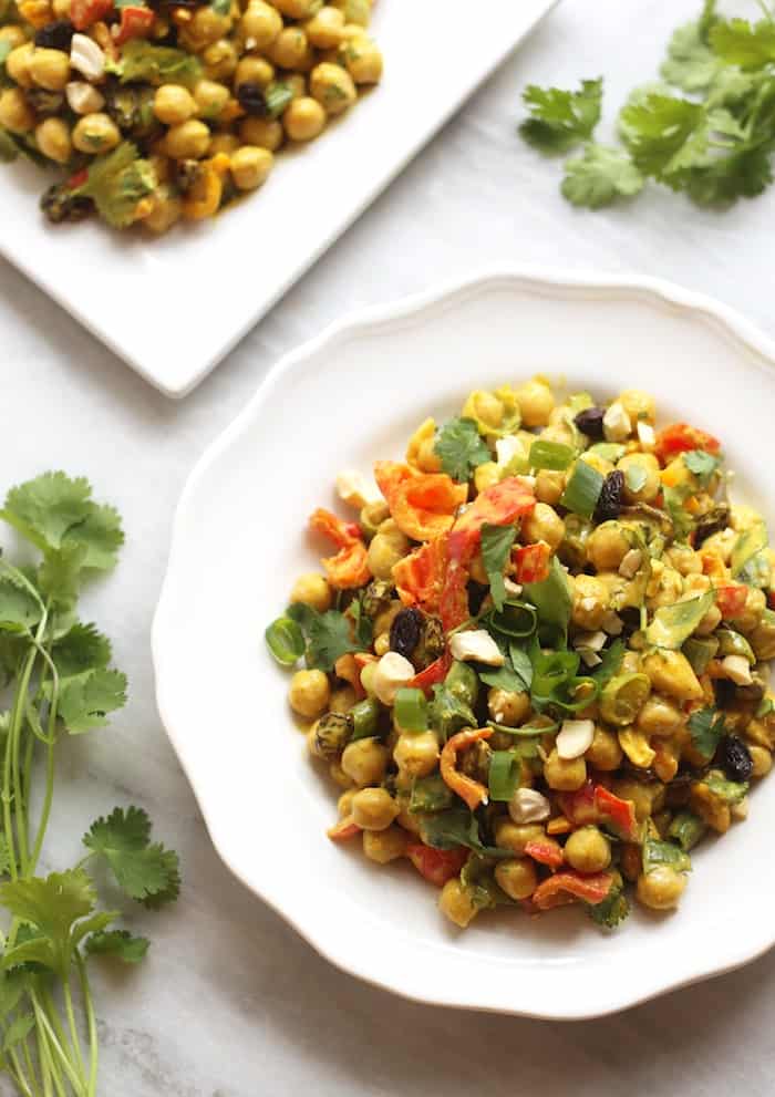 chickpea salad on a plate with cashews and green onions.