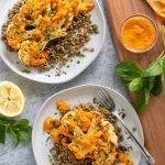 Cauliflower on a plate with lentils, capers and mint.