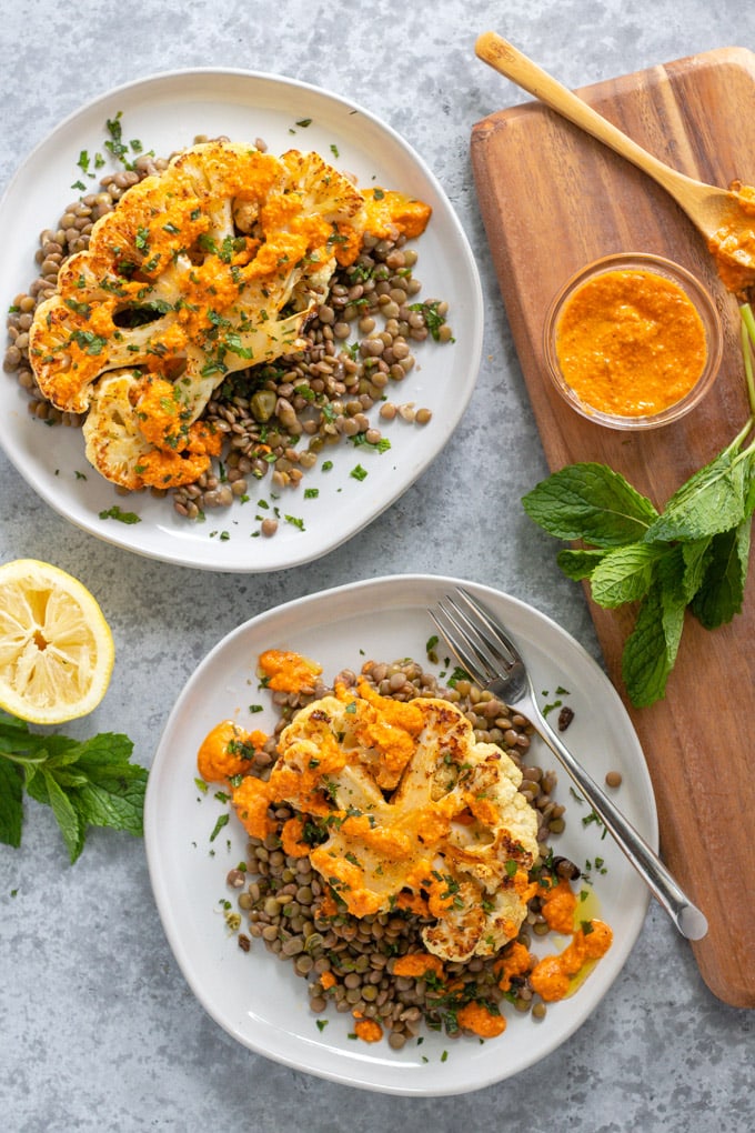 cauliflower steaks on a plate with fork and mint leaves.