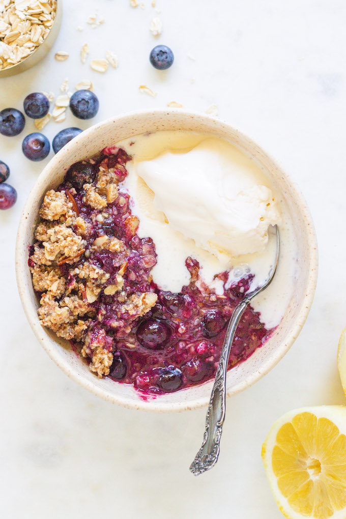 Melting ice cream in a bowl with a spoon and blueberries