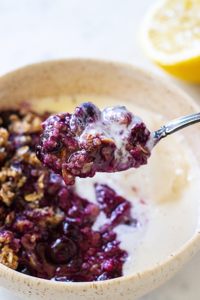 Spoon full of crisp with ice cream and lemon.