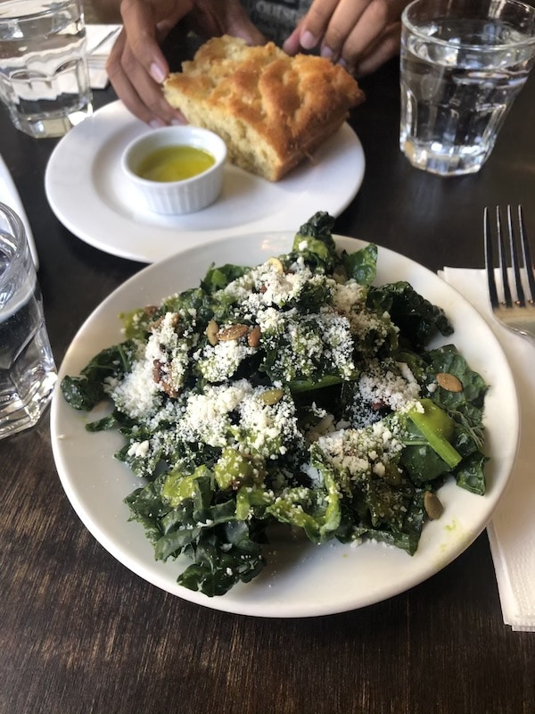 Salad on a plate with a fork next to it.