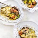 chicken foil packets on plates with a fork.