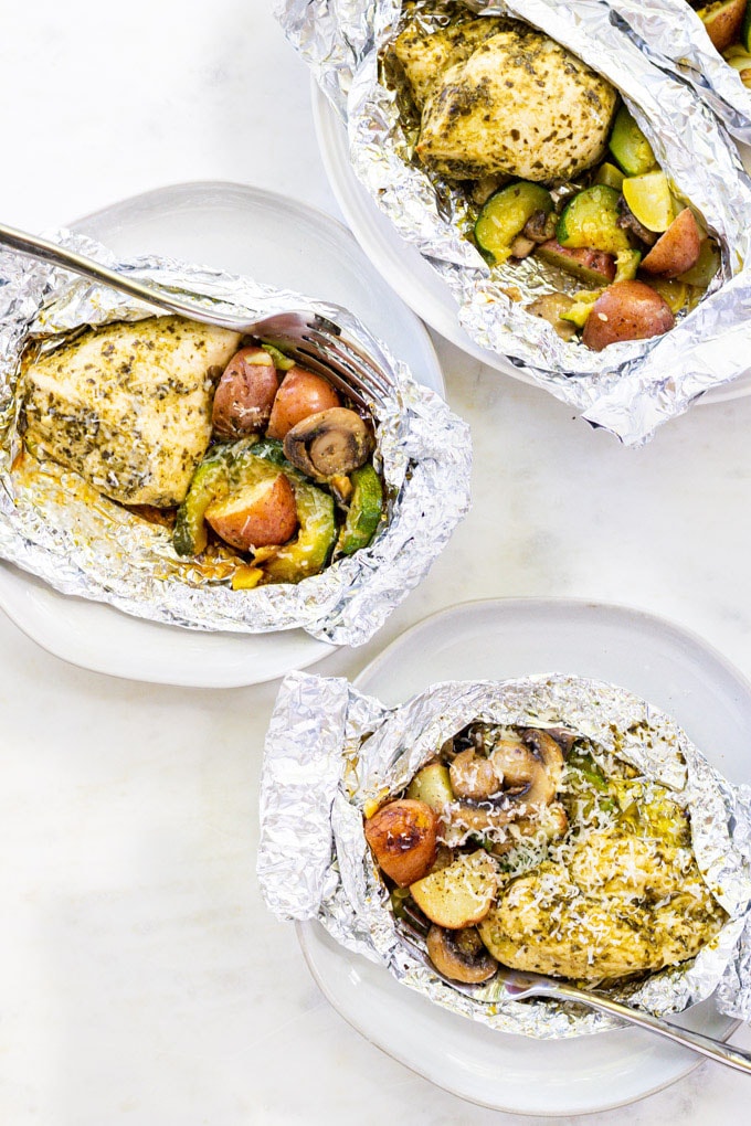 chicken and vegetables in foil packets with a fork