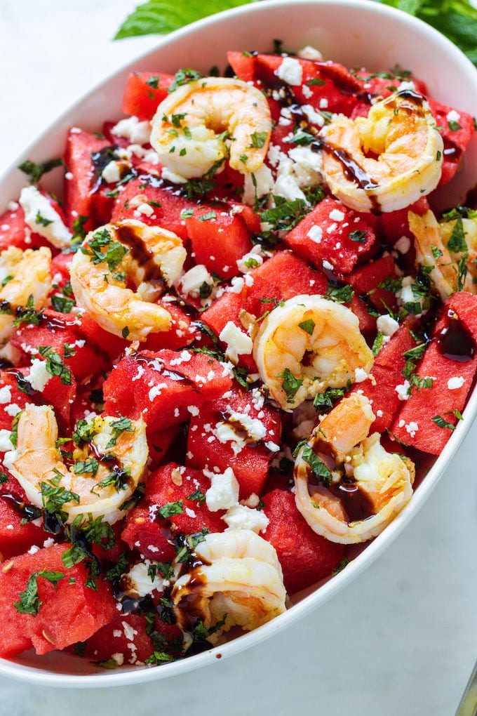 shrimp, feta and watermelon in a bowl with balsamic drizzled over it.