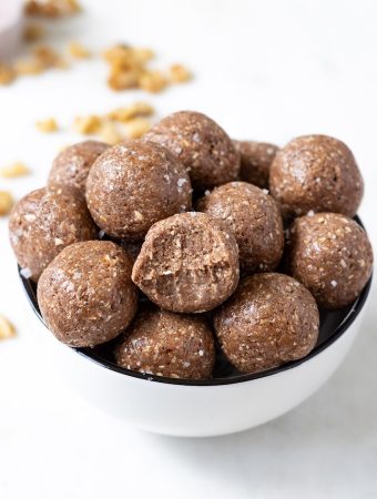 A bowl of protein balls with bite mark in one.