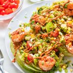 Grilled romaine with shrimp and dressing on top.
