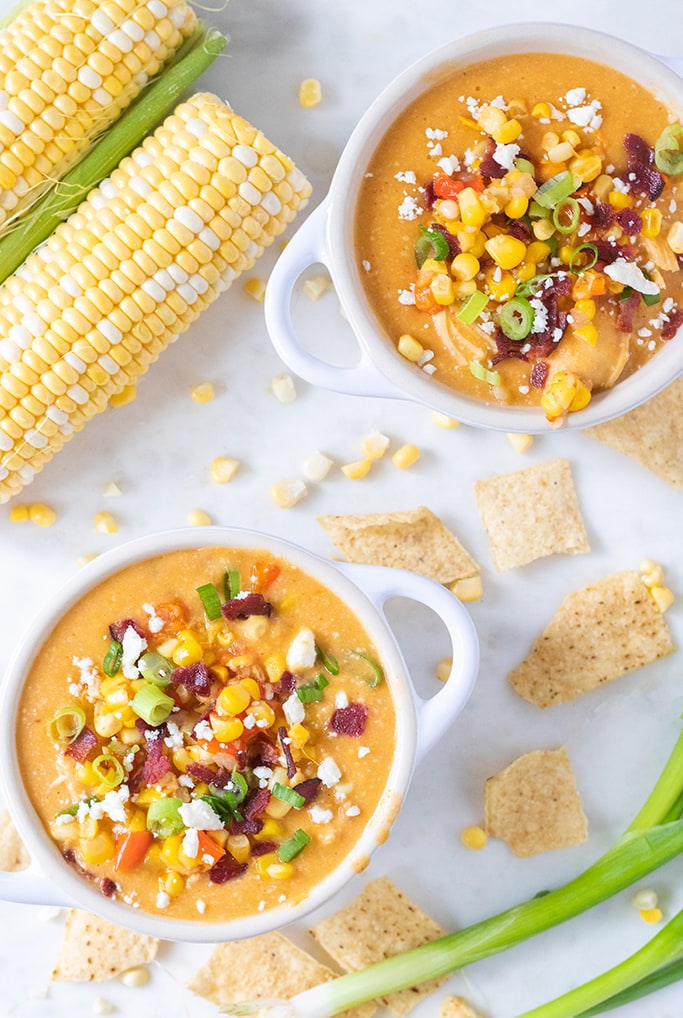 Overhead view of corn chowder with toppings