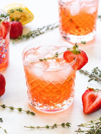 strawberry cocktail with vodka and thyme around it.