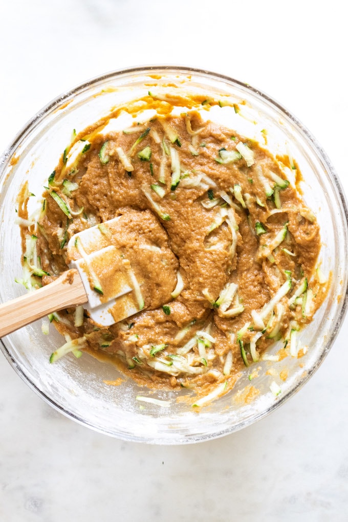 Mixing bowl filled with muffin ingredients and a spatula.