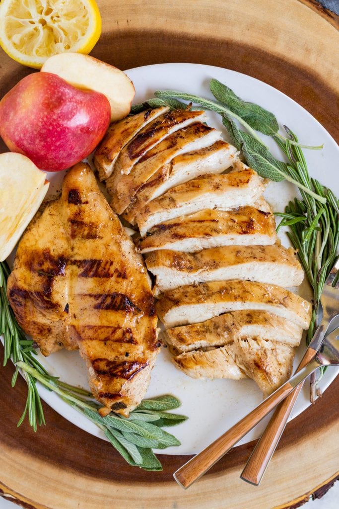 Apple Cider chicken on a plate with herbs and forks. 