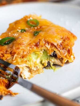 A piece of enchilada lasagna stuffed with avocado cream