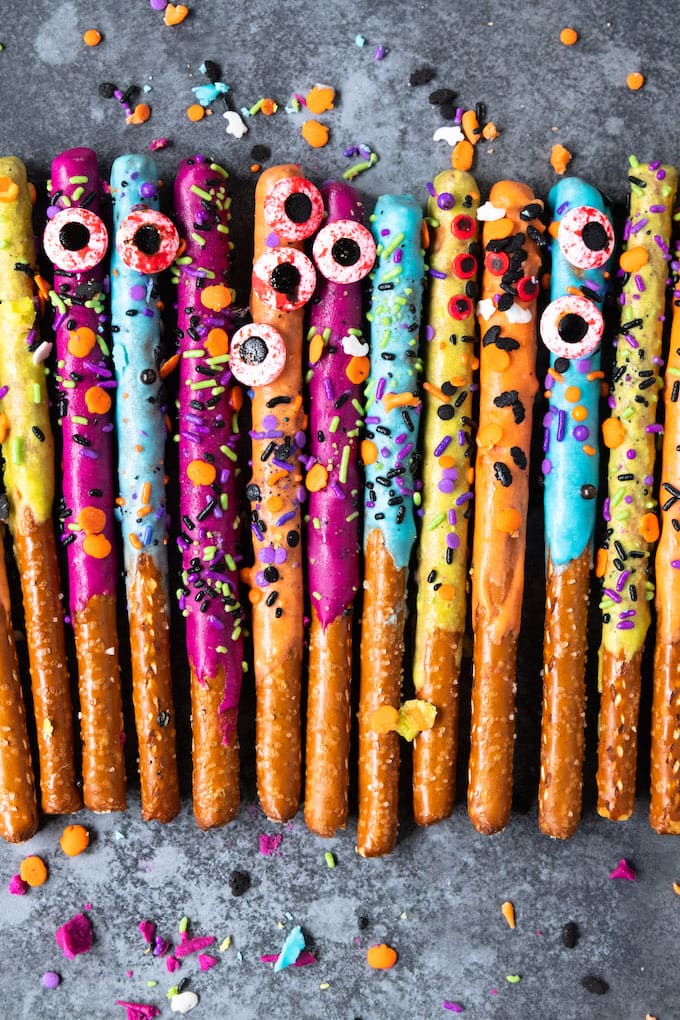 Pretzels covered in sprinkles and colors in a line up. 