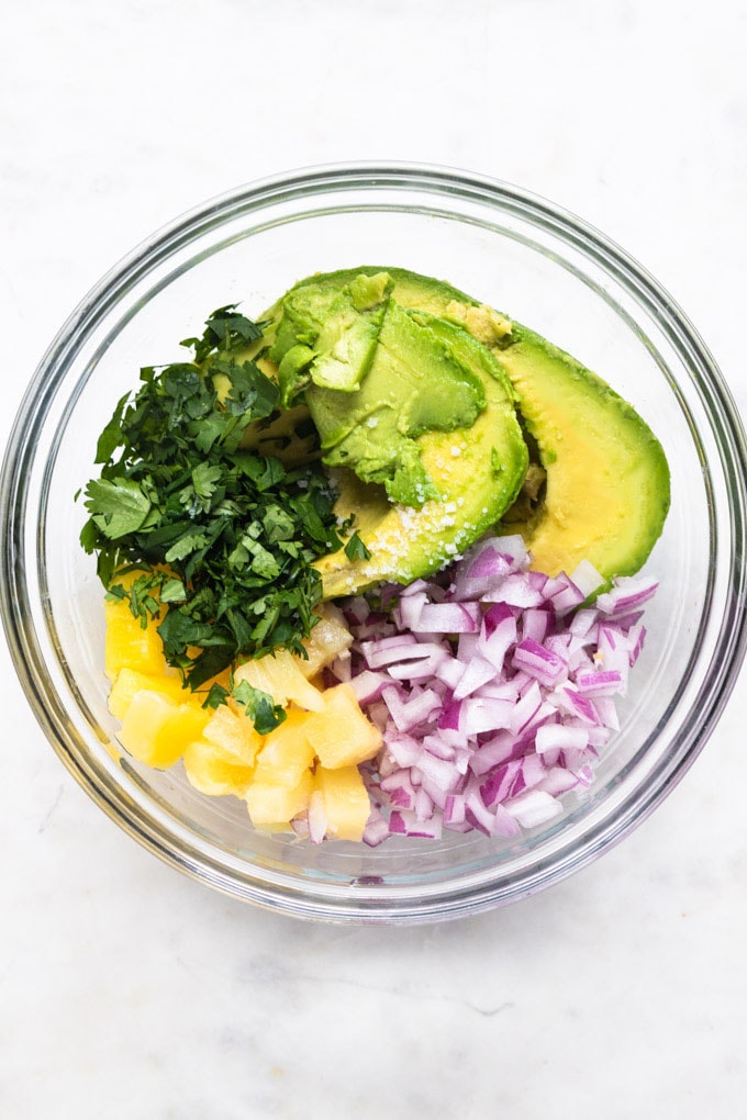 Ingredients for guacamole with red onions, pineapple and avocado.