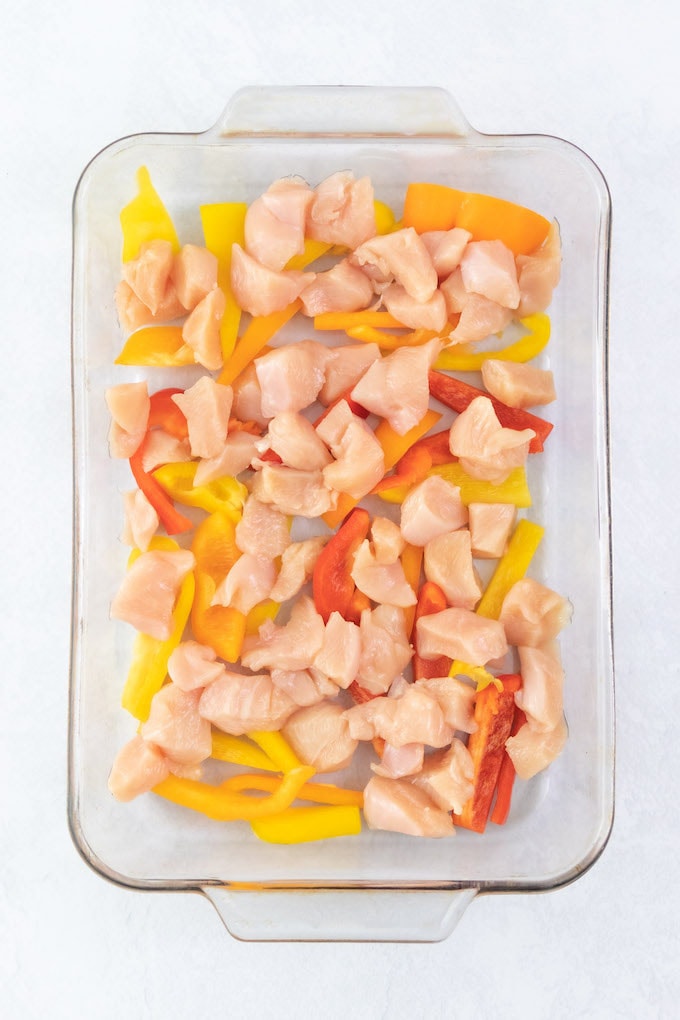 Chicken and peppers in a casserole dish.