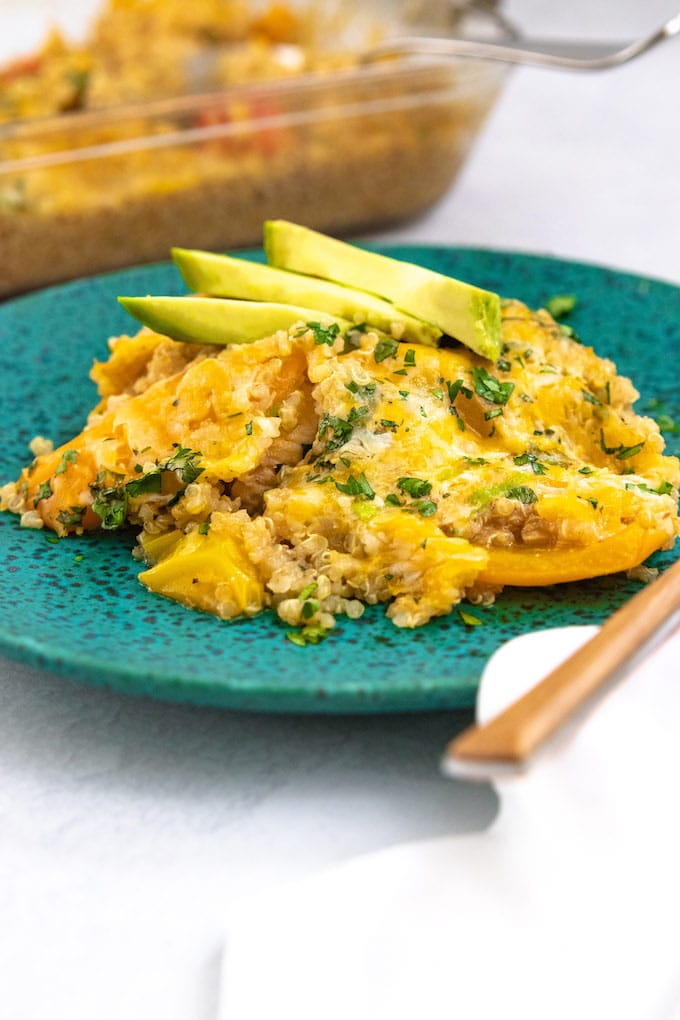 A pile of chicken fajita casserole with cheese and avocado on top. 