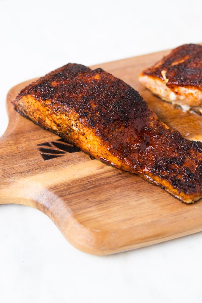 Salmon on a plank with blackened seasoning.