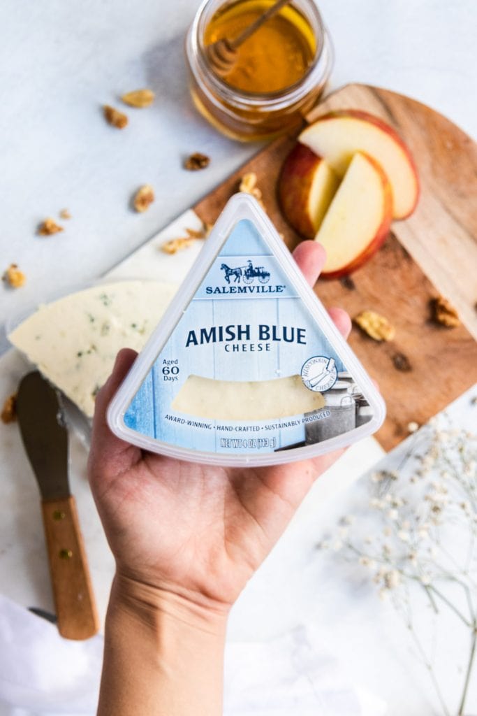 Amish Blue cheese being held by a hand.