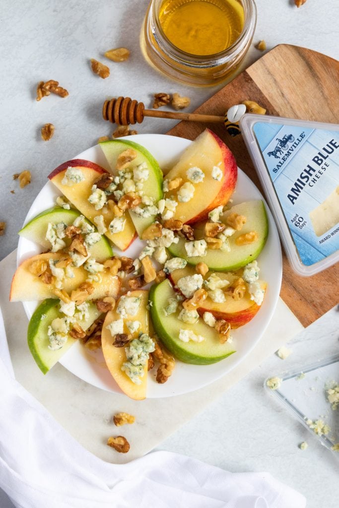 Apples on a plate with hot honey and walnuts.