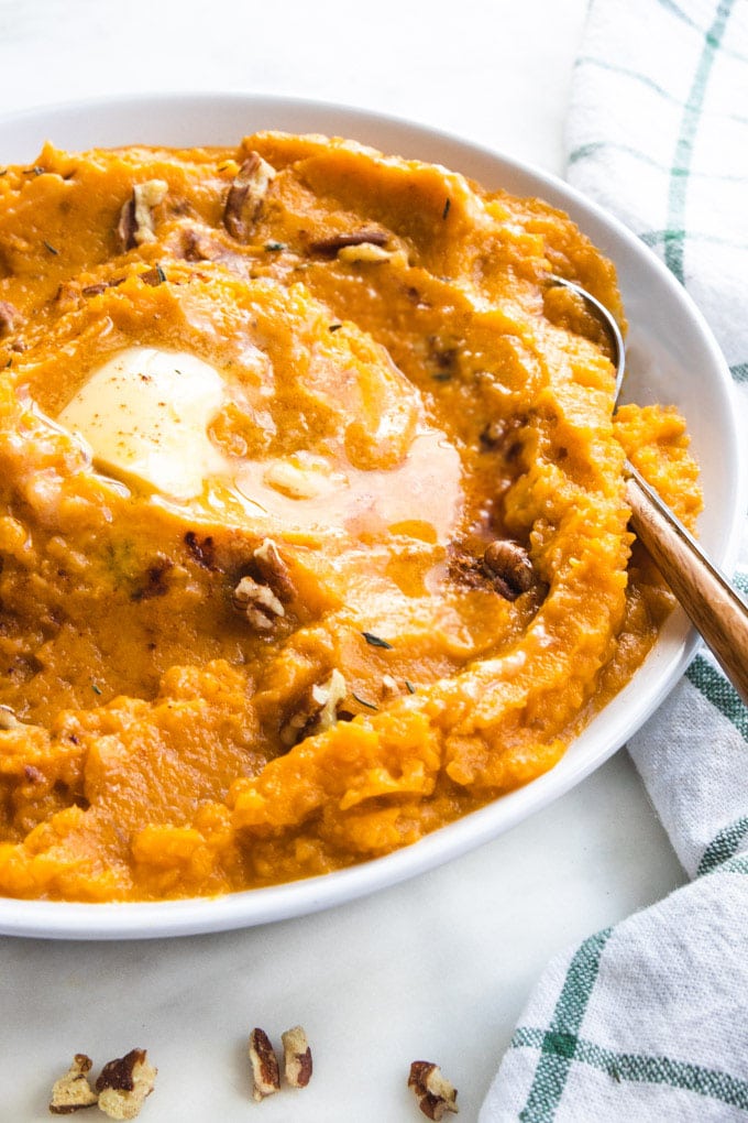 a bowl of sweet potatoes with a spoon.