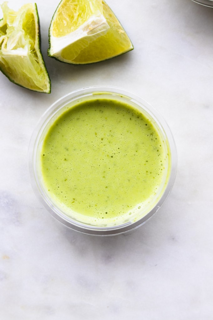 Cilantro lime dressing in a small container for taco salad meal prep bowls.