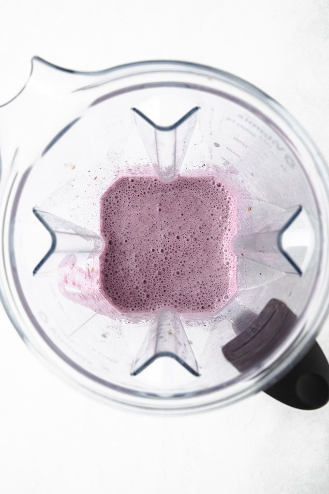 Inside of a blender with a blueberry smoothie in it.